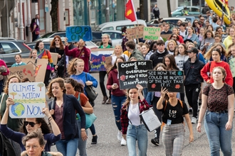 young people at a climate march all holding placards