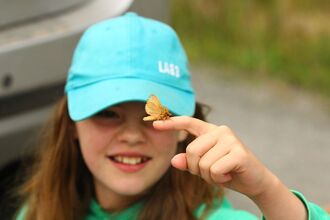 Young person holding a moth