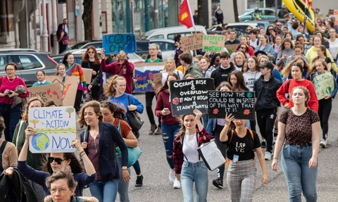 young people at a climate march all holding placards