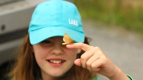 Young person holding a moth