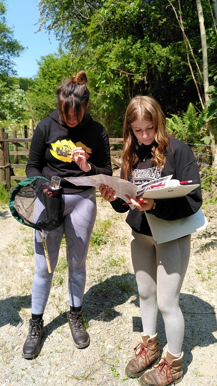A photo of two girls looking at an ID guide