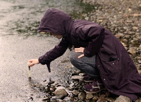 Water sample being taken in river