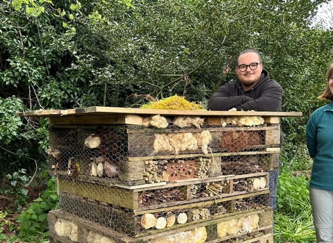 2 people standing next to bug hotel